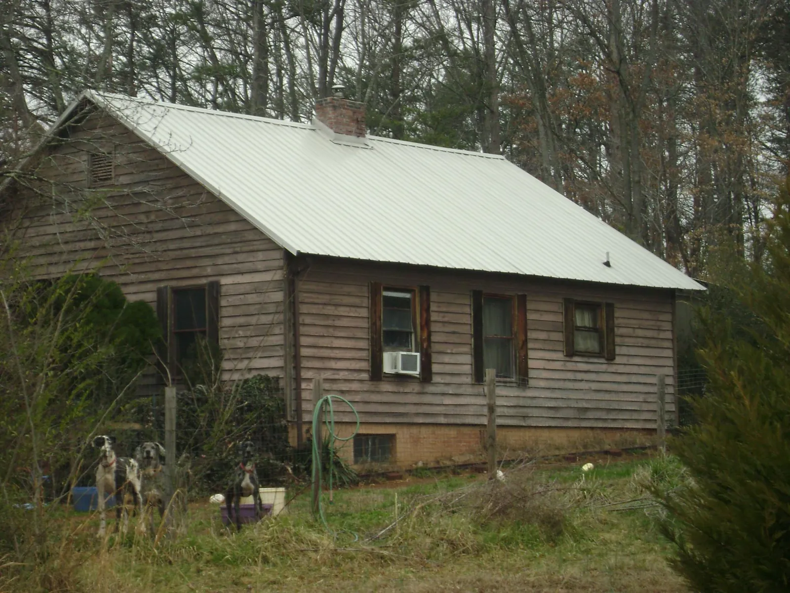 White metal roof on an old wood sided farmhouse, from a Metal Roof Installation job in Santa Fe
